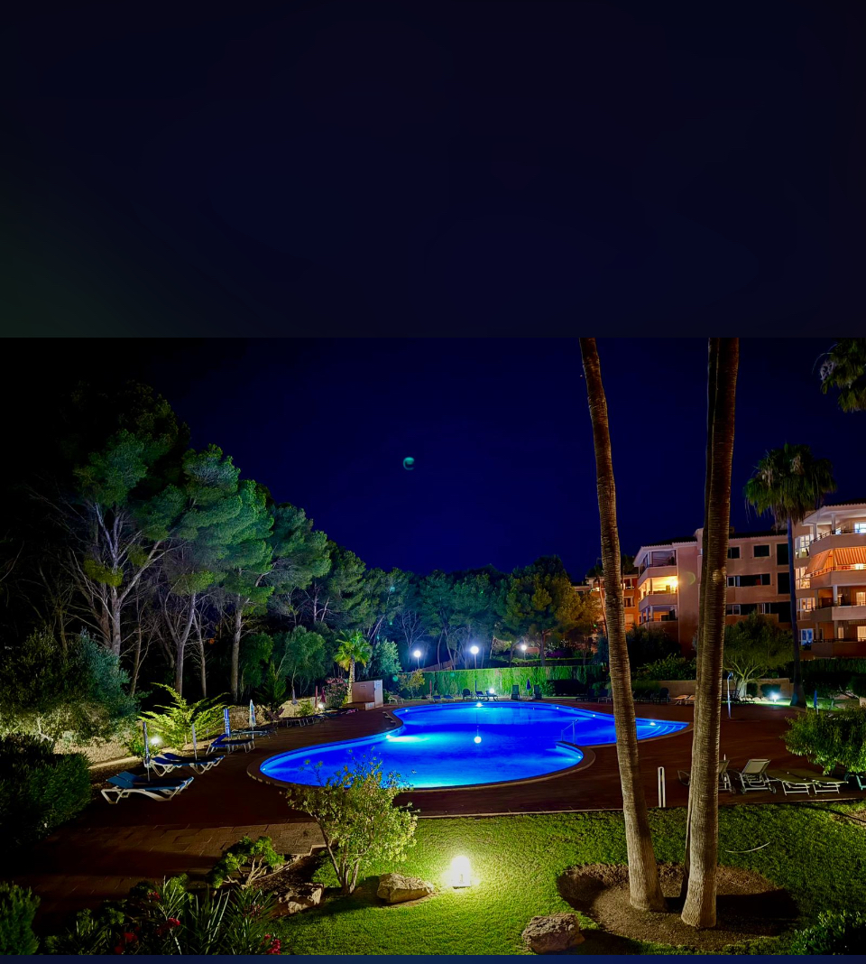 Beleuchteter Pool in einer Wohnanlage bei Nacht – entspannte Atmosphäre an einem der schönsten Orte auf Mallorca