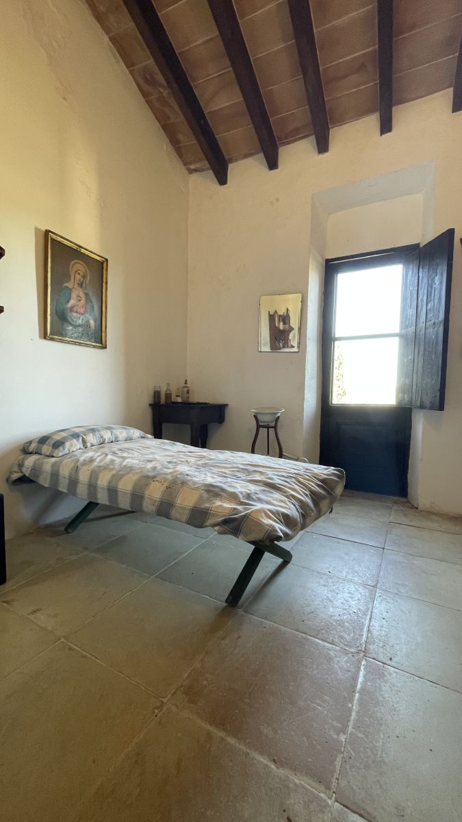 Historisches Schlafzimmer des Knechtes im Herrenhaus Els Calderers auf Mallorca, das den Alltag vergangener Zeiten zeigt.