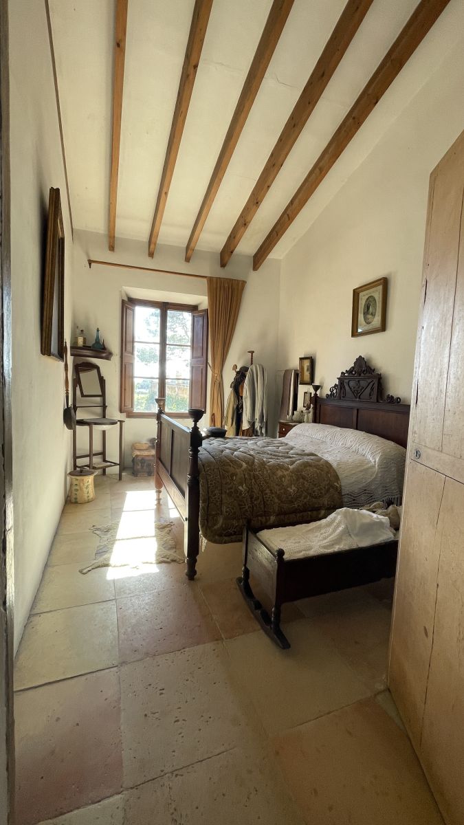 Schlafzimmer des Dienstherren im Herrenhaus Els Calderers auf Mallorca, mit authentischem historischen Ambiente.
