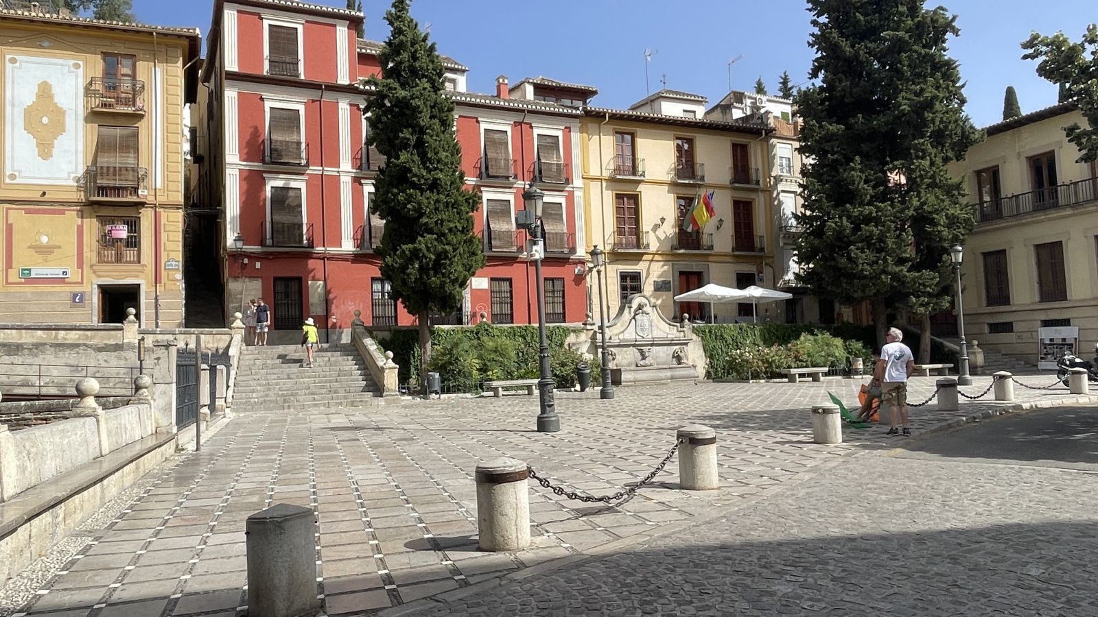Claudia und Axel auf einem sonnigen Platz mit großen Stadtpalästen im Zentrum von Granada