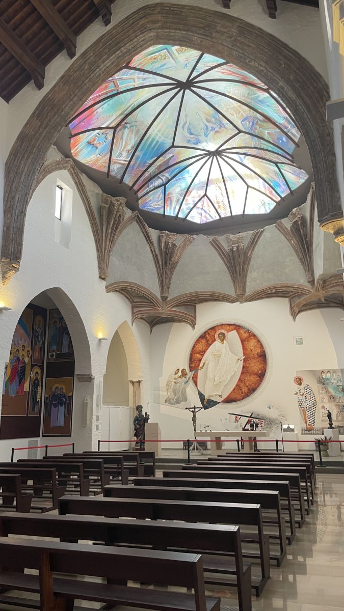 Schlichter Kircheninnenraum von San Nicolás mit weißen Wänden und Altar