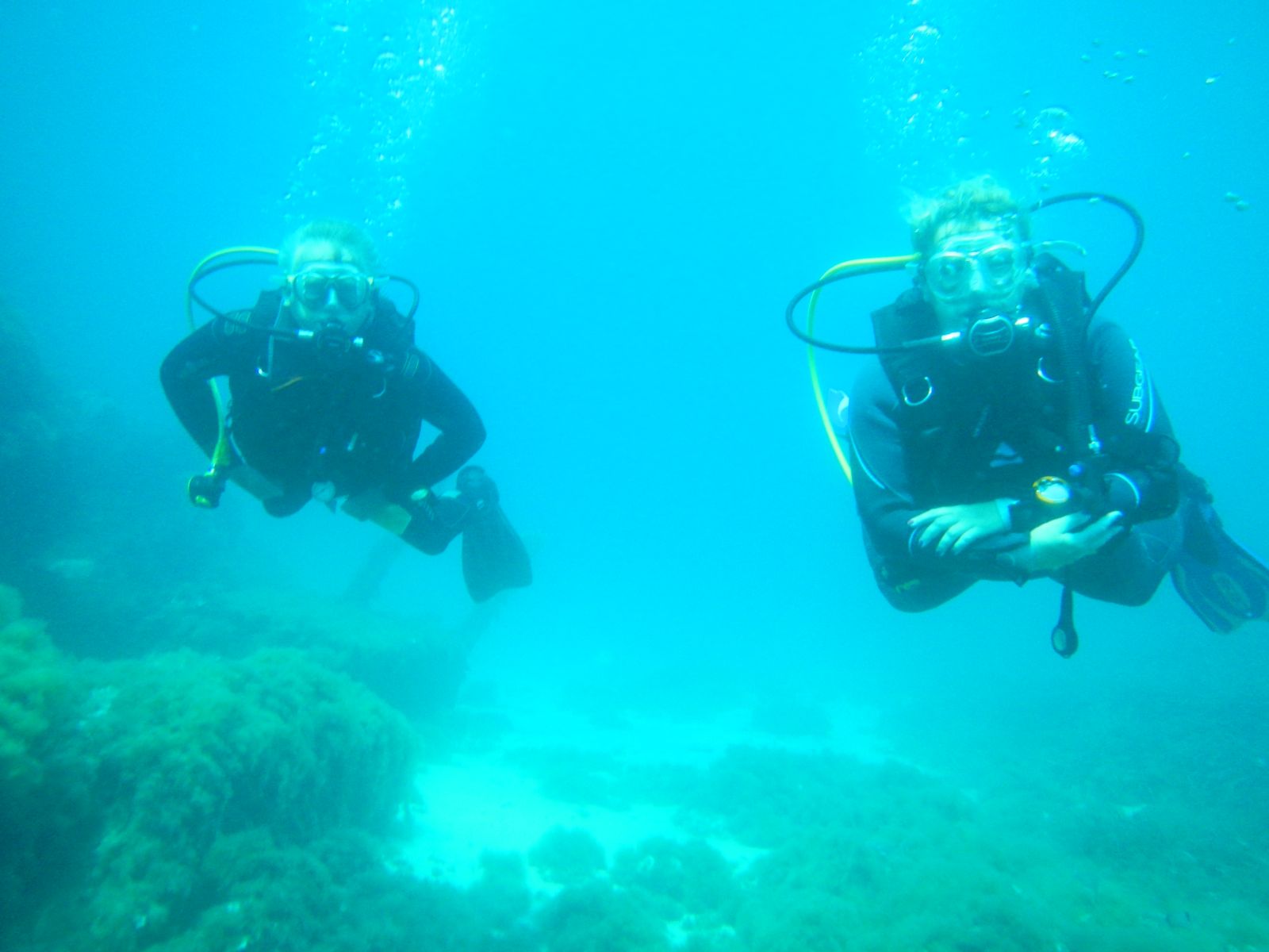 Claudia und Axel beim Schweben durch das ruhige, glasklare Mittelmeer vor Mallorca im Oktober, im Hintergrund leichte Strömung und Sonnenlicht, das durch die Wasseroberfläche fällt.