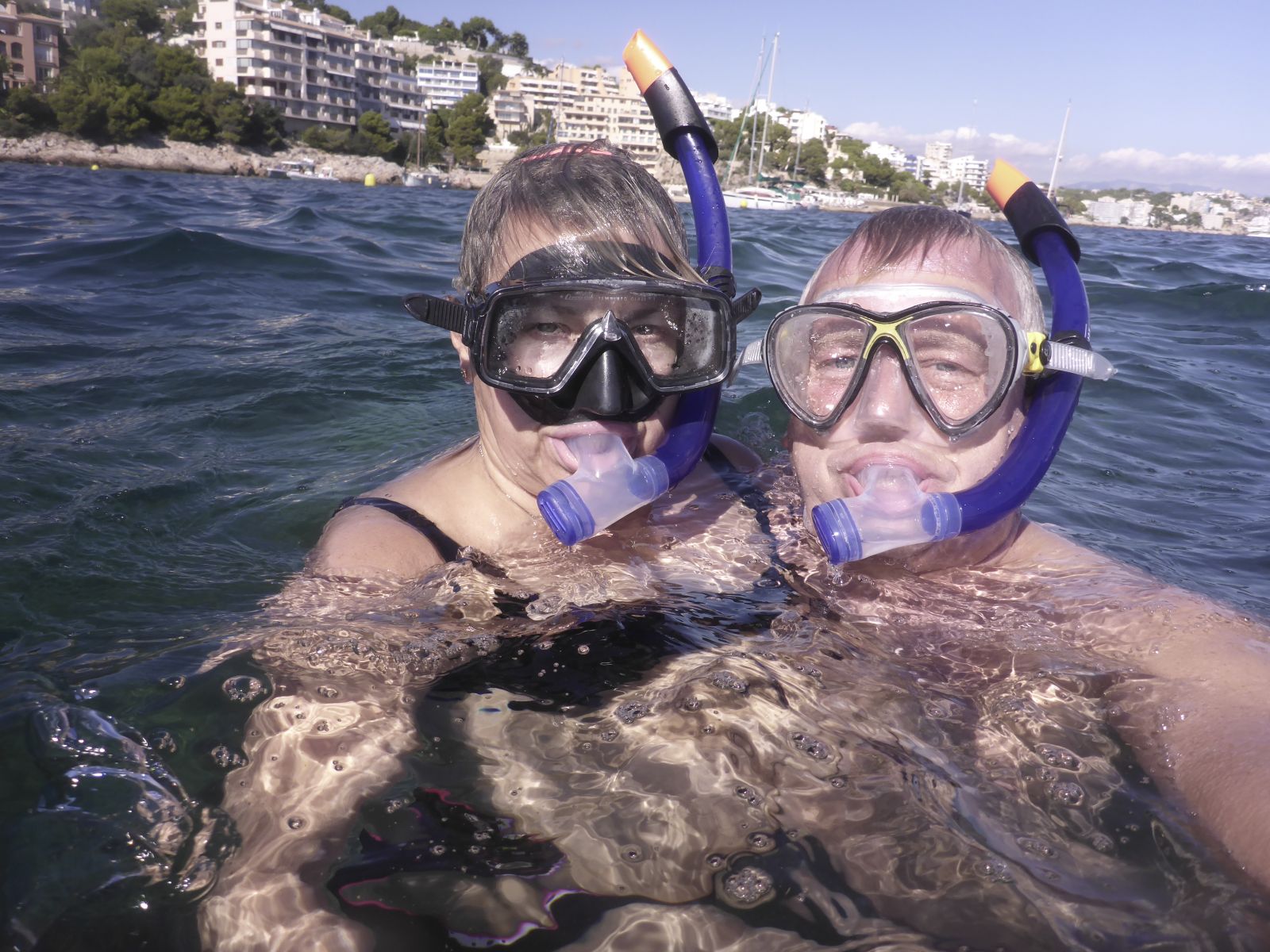 Axel und Claudia schnorcheln im klaren Wasser vor Mallorcas Küste, umgeben von Felsen und Fischschwärmen – perfekte Bedingungen für Wassersport im Oktober auf Mallorca.